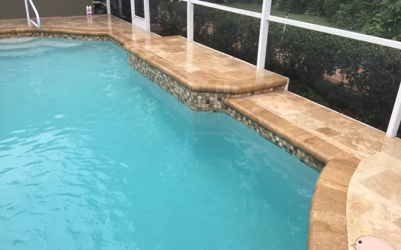 Luxurious pool with smooth quartz finish and elegant tile edging, showcasing Kristi's Pool Service quality craftsmanship.